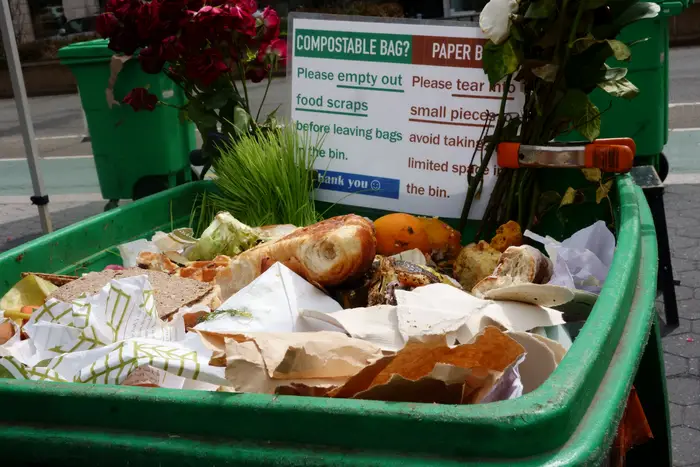 Bin with compost items and suggestions on what to do with paper and compostable bags, Union Square Farmer's Market.